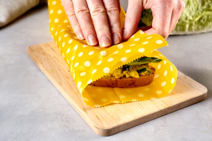hands wrapping a healthy sandwich in beeswax